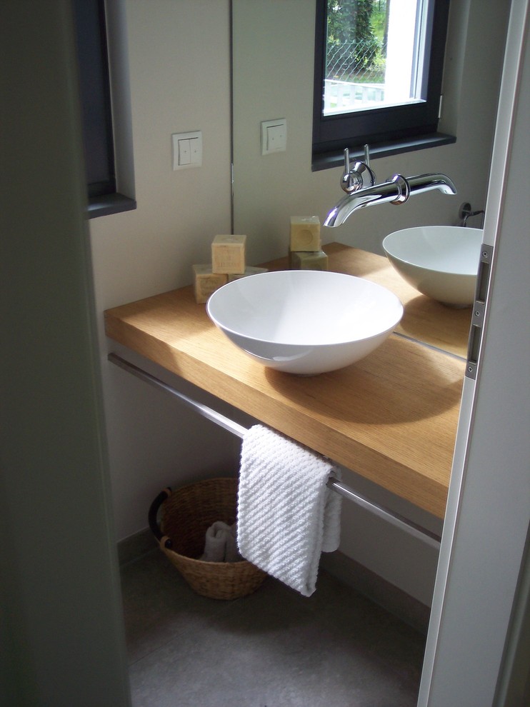 Photo of a small modern powder room in Berlin with brown benchtops.