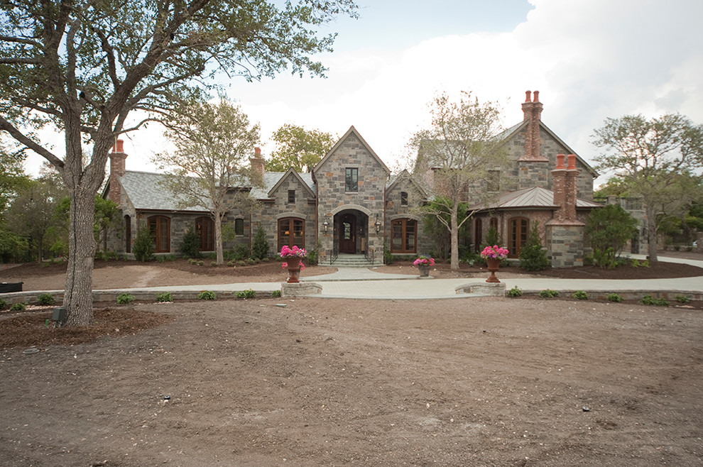 This is an example of an expansive mediterranean two-storey grey exterior in Houston with stone veneer.