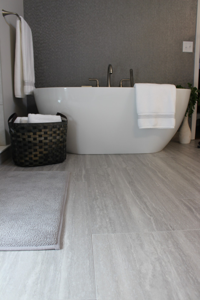 Large transitional master ceramic tile, gray floor, double-sink and wallpaper freestanding bathtub photo with white cabinets, gray walls, an undermount sink, quartz countertops, white countertops and a built-in vanity