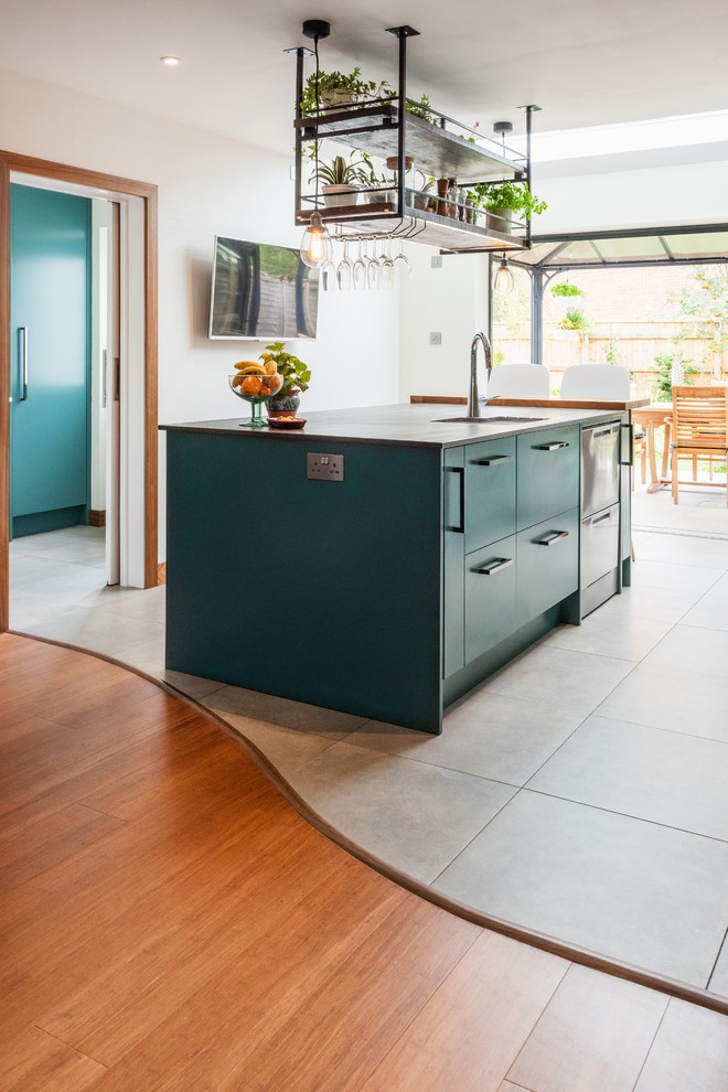 Mid-sized contemporary galley eat-in kitchen in Other with a drop-in sink, turquoise cabinets, quartzite benchtops, metallic splashback, slate splashback, stainless steel appliances, porcelain floors, white floor and multi-coloured benchtop.