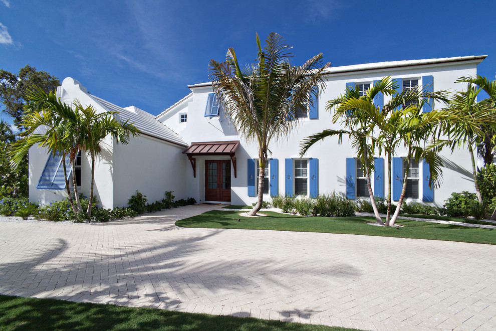 Design ideas for a tropical two-storey stucco white exterior in Miami.