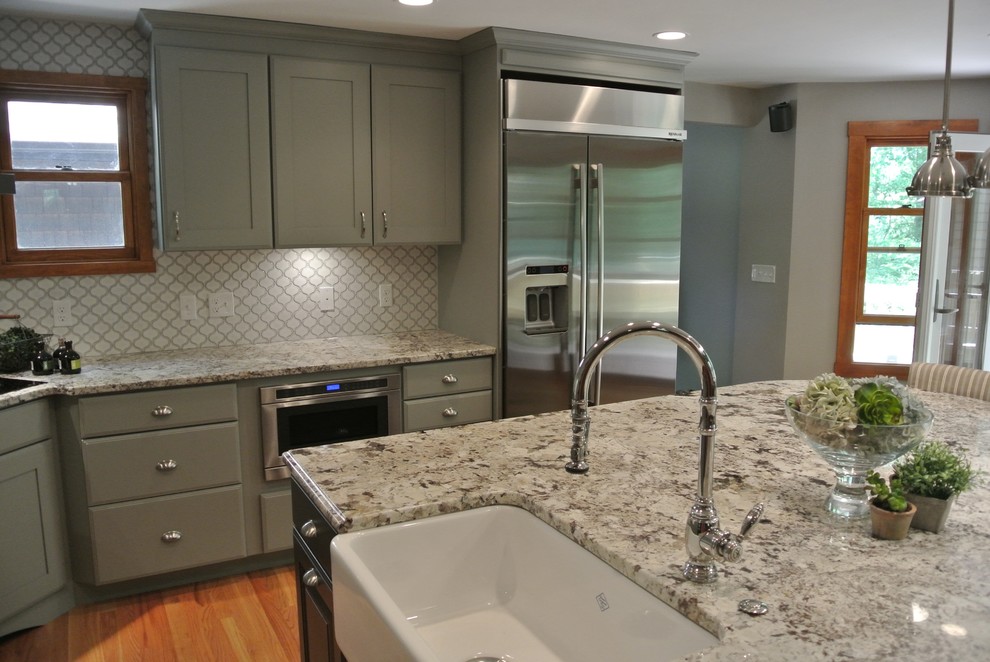 Inspiration for a large transitional l-shaped light wood floor eat-in kitchen remodel in Boston with a farmhouse sink, shaker cabinets, gray cabinets, granite countertops, white backsplash, ceramic backsplash, stainless steel appliances, an island and gray countertops