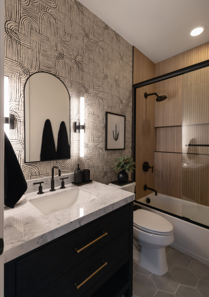 Alcove bathtub - transitional 3/4 brown tile gray floor, single-sink and wallpaper alcove bathtub idea in Phoenix with black cabinets, gray walls, an undermount sink, gray countertops, a niche and a built-in vanity
