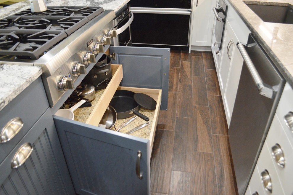 Example of a large dark wood floor kitchen design with shaker cabinets, blue cabinets, quartzite countertops and an island