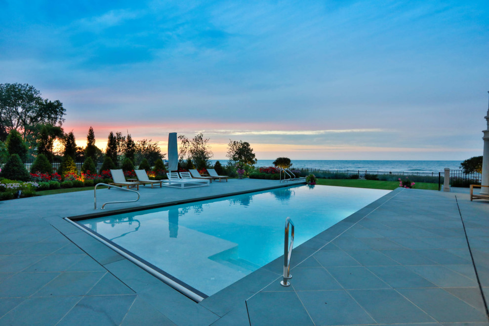 Imagen de piscina alargada tradicional de tamaño medio rectangular en patio con paisajismo de piscina y adoquines de piedra natural