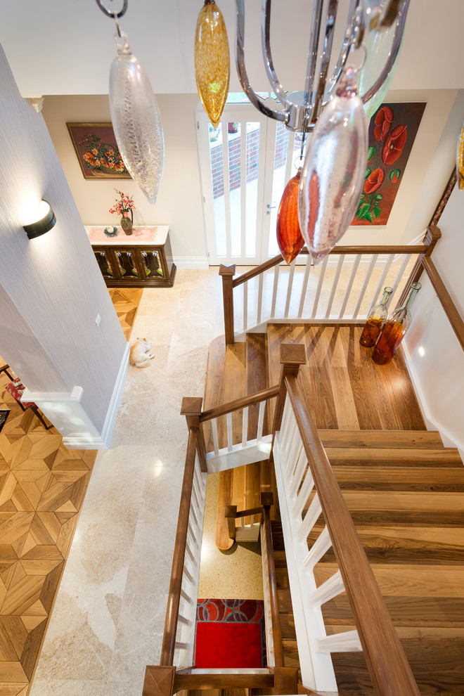Photo of a large traditional wood u-shaped staircase in Melbourne with wood risers.