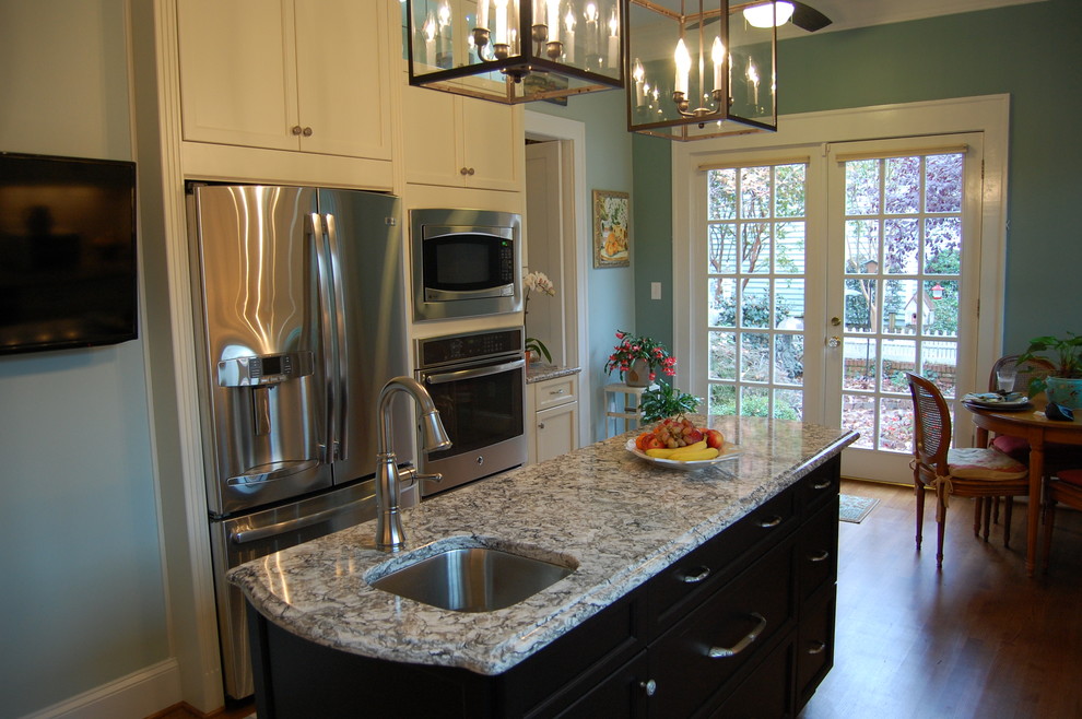 Example of a transitional u-shaped eat-in kitchen design in Raleigh with an undermount sink, recessed-panel cabinets, white cabinets, quartzite countertops, white backsplash, subway tile backsplash and stainless steel appliances