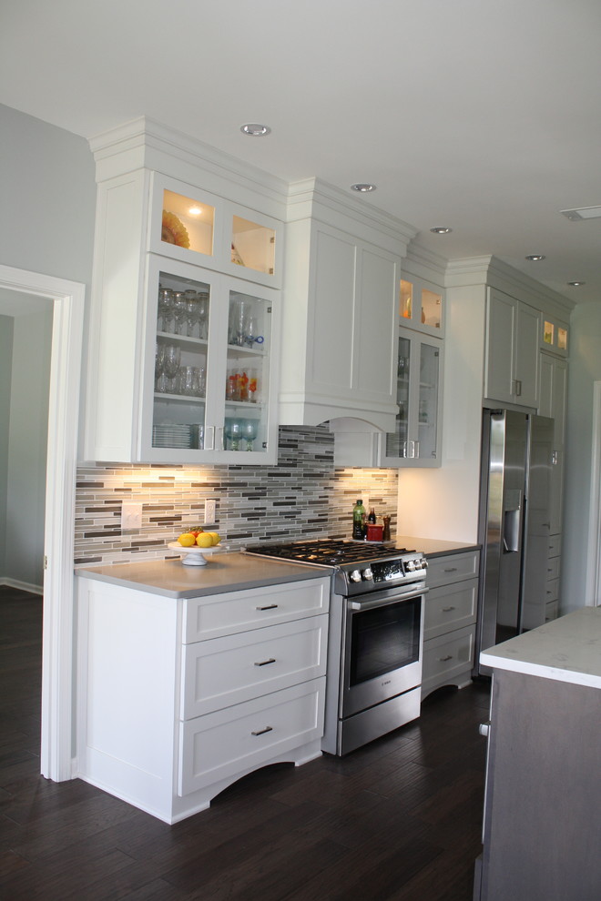 Enclosed kitchen - mid-sized transitional galley dark wood floor and brown floor enclosed kitchen idea in Austin with an undermount sink, shaker cabinets, white cabinets, quartz countertops, multicolored backsplash, matchstick tile backsplash, stainless steel appliances and an island