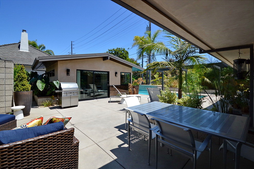 Design ideas for a large midcentury backyard patio in Los Angeles with a container garden, concrete slab and a roof extension.