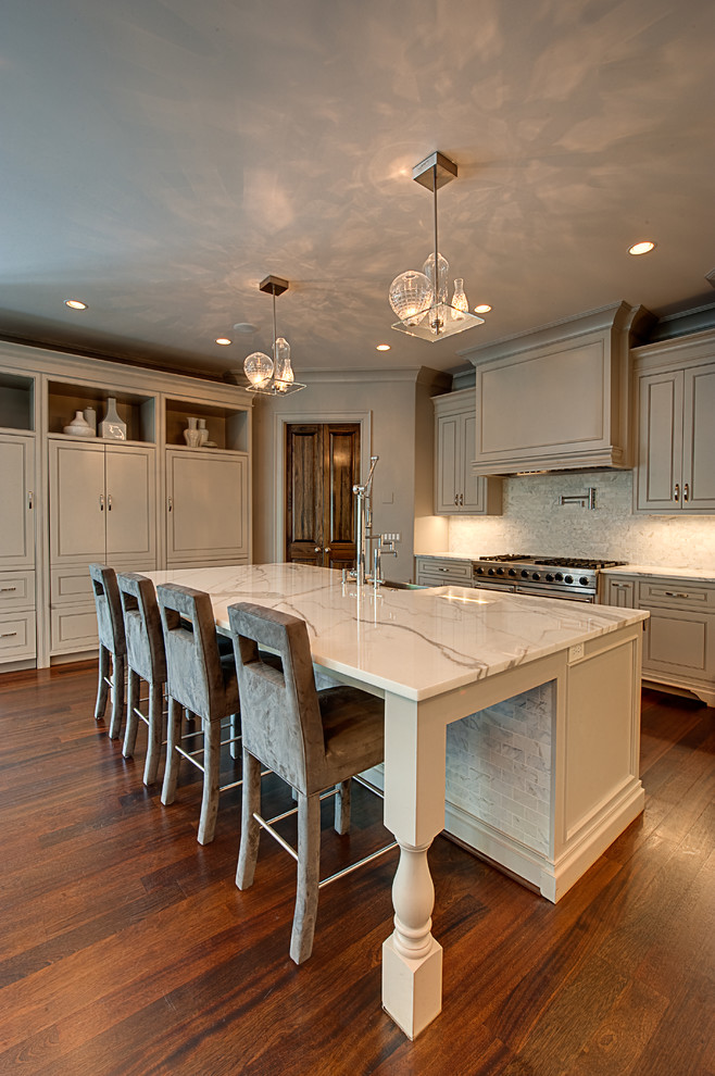 Example of a large transitional u-shaped medium tone wood floor open concept kitchen design in Atlanta with a farmhouse sink, beaded inset cabinets, white cabinets, marble countertops, white backsplash, porcelain backsplash, paneled appliances and an island
