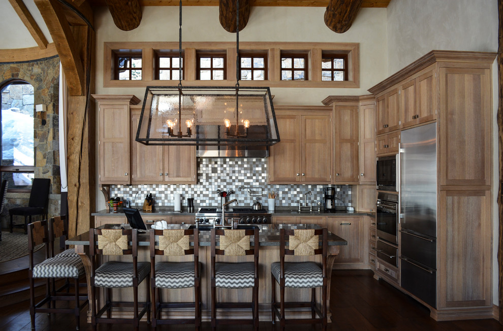 Example of a mid-sized mountain style l-shaped open concept kitchen design in Denver with shaker cabinets, light wood cabinets, metallic backsplash, mosaic tile backsplash, stainless steel appliances and an island