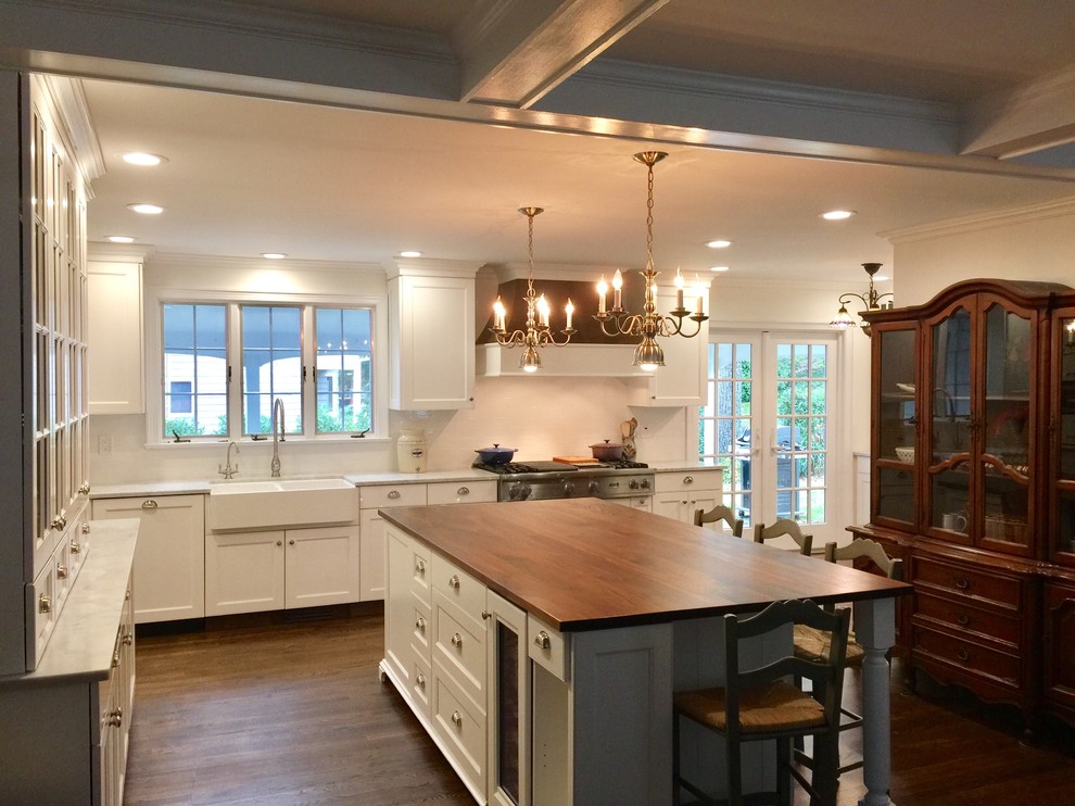 Inspiration for a large traditional l-shaped eat-in kitchen in Philadelphia with a farmhouse sink, shaker cabinets, white cabinets, marble benchtops, white splashback, ceramic splashback, stainless steel appliances, dark hardwood floors and with island.