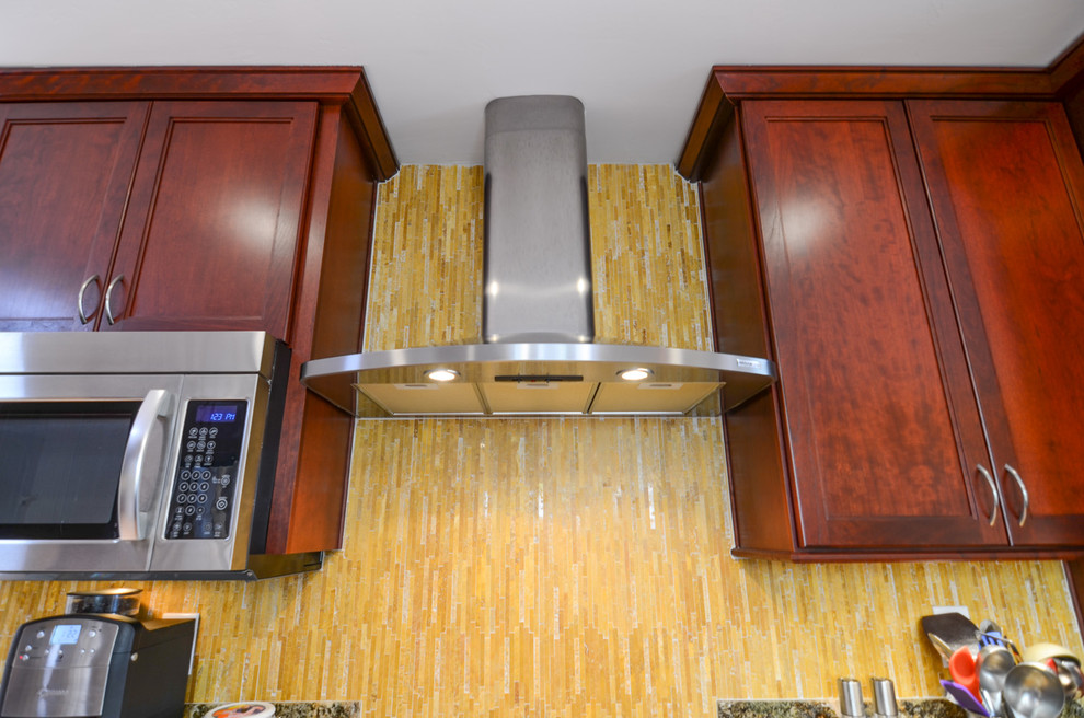 Example of a large trendy galley medium tone wood floor eat-in kitchen design in Tampa with a single-bowl sink, recessed-panel cabinets, red cabinets, granite countertops, yellow backsplash, glass tile backsplash and stainless steel appliances