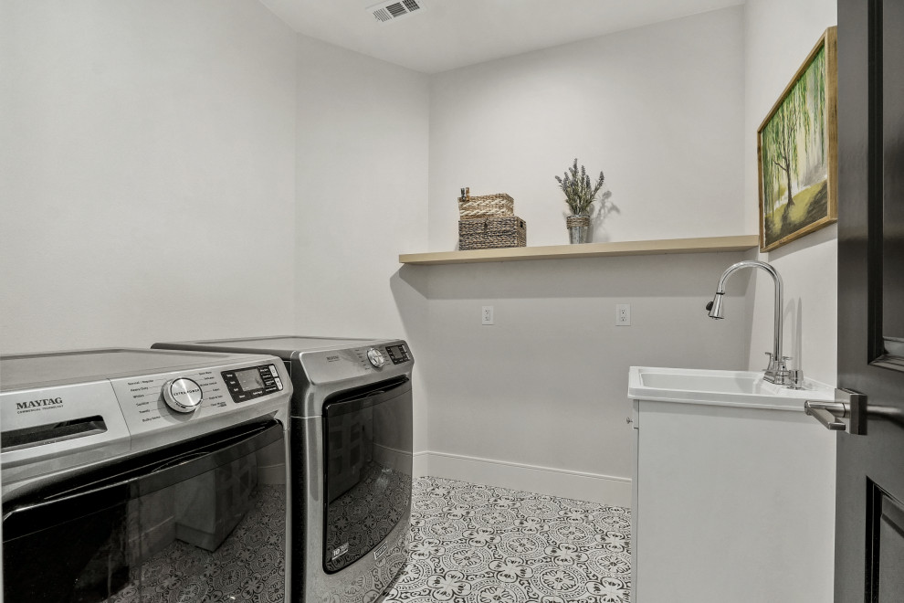 Esempio di una grande sala lavanderia american style con pareti bianche, lavatrice e asciugatrice affiancate e pavimento multicolore