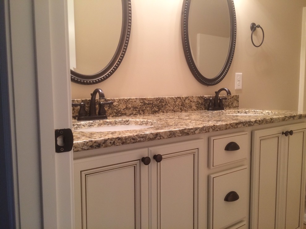 This is an example of a mid-sized traditional bathroom in Other with recessed-panel cabinets, white cabinets, granite benchtops and terra-cotta floors.