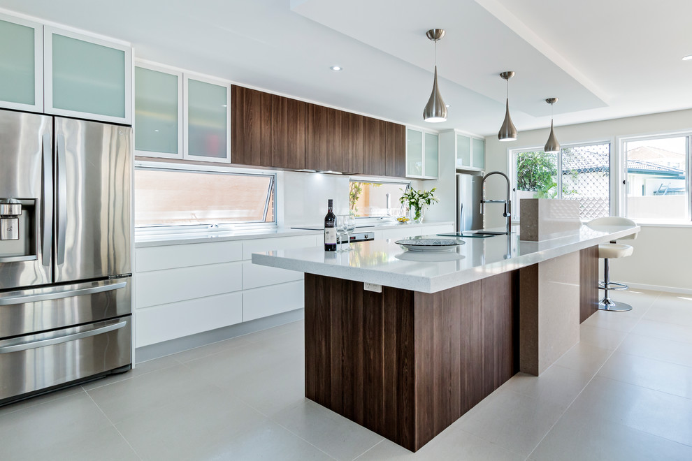 Design ideas for a large contemporary galley kitchen in Gold Coast - Tweed with a double-bowl sink, flat-panel cabinets, dark wood cabinets, quartz benchtops, stone slab splashback, stainless steel appliances, porcelain floors and with island.