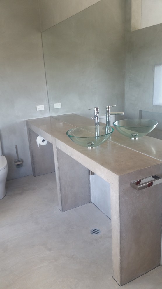 Design ideas for an industrial bathroom in Sunshine Coast with concrete benchtops.