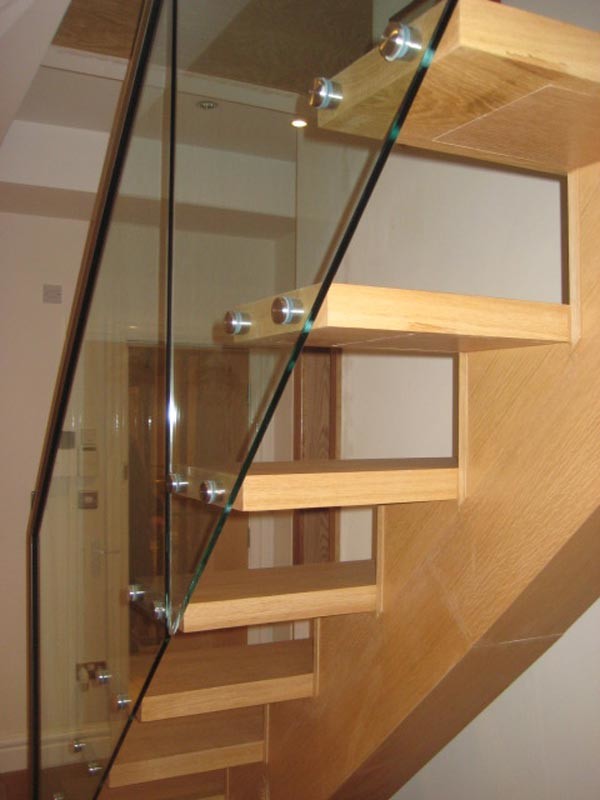 Modern wood straight staircase in Other with glass risers.