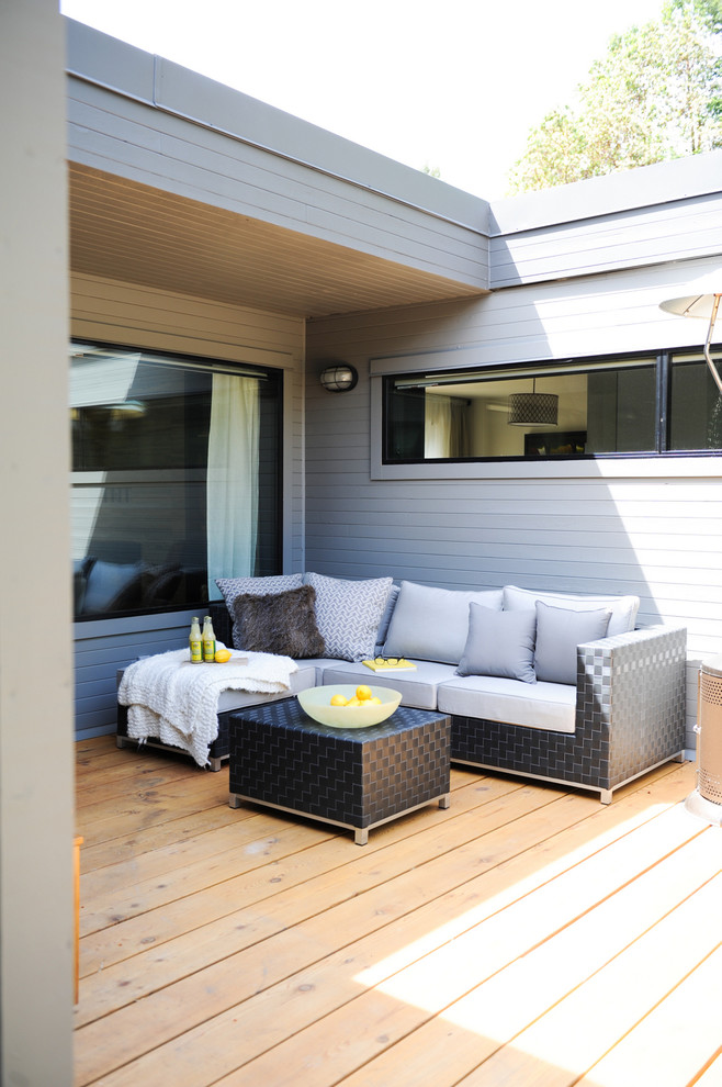 Inspiration for a mid-sized contemporary backyard deck in Vancouver with a roof extension.