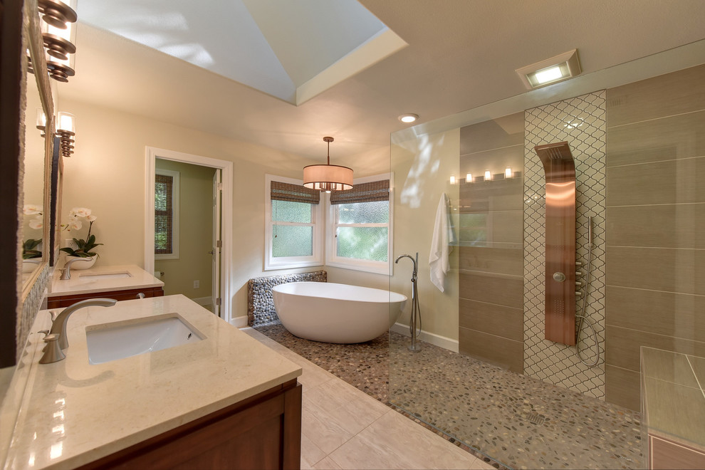 This is an example of a large transitional master bathroom in Sacramento with flat-panel cabinets, medium wood cabinets, a freestanding tub, a corner shower, a two-piece toilet, brown tile, pebble tile, beige walls, slate floors, an undermount sink, quartzite benchtops, beige floor and an open shower.