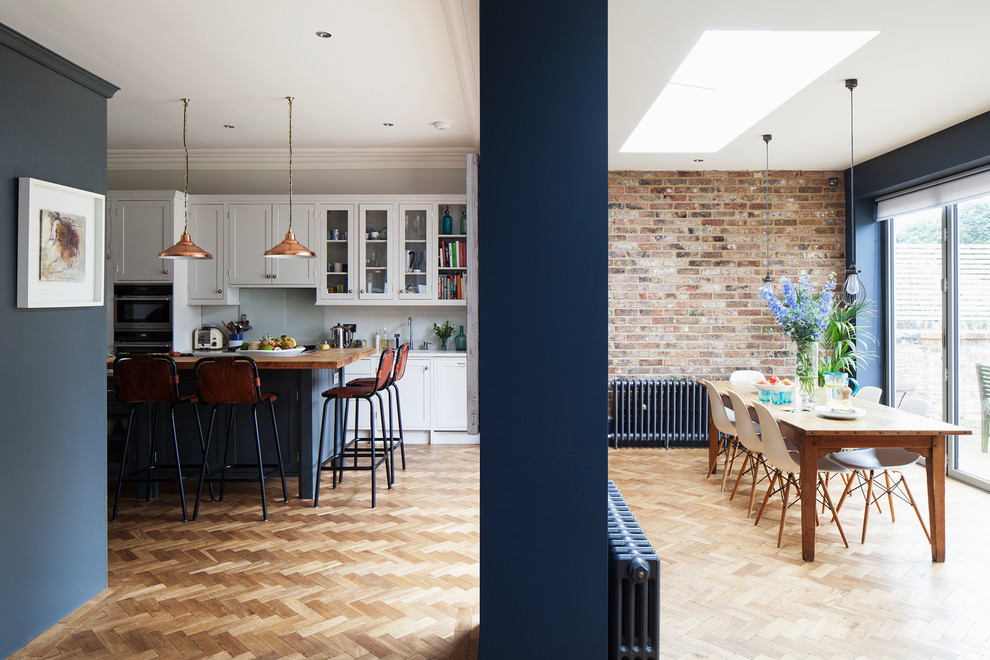 Large transitional l-shaped eat-in kitchen in Sussex with an integrated sink, shaker cabinets, grey cabinets, marble benchtops, light hardwood floors, with island, brown floor, white benchtop and coffered.