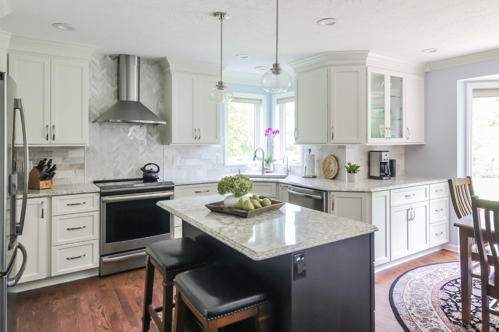 Design ideas for a large transitional u-shaped eat-in kitchen in Detroit with an undermount sink, shaker cabinets, white cabinets, quartz benchtops, white splashback, marble splashback, stainless steel appliances, medium hardwood floors, with island, brown floor and white benchtop.