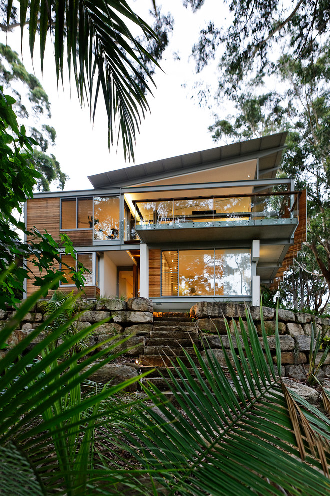 Inspiration for a mid-sized contemporary two-storey brown house exterior in Sydney with wood siding, a flat roof and a metal roof.