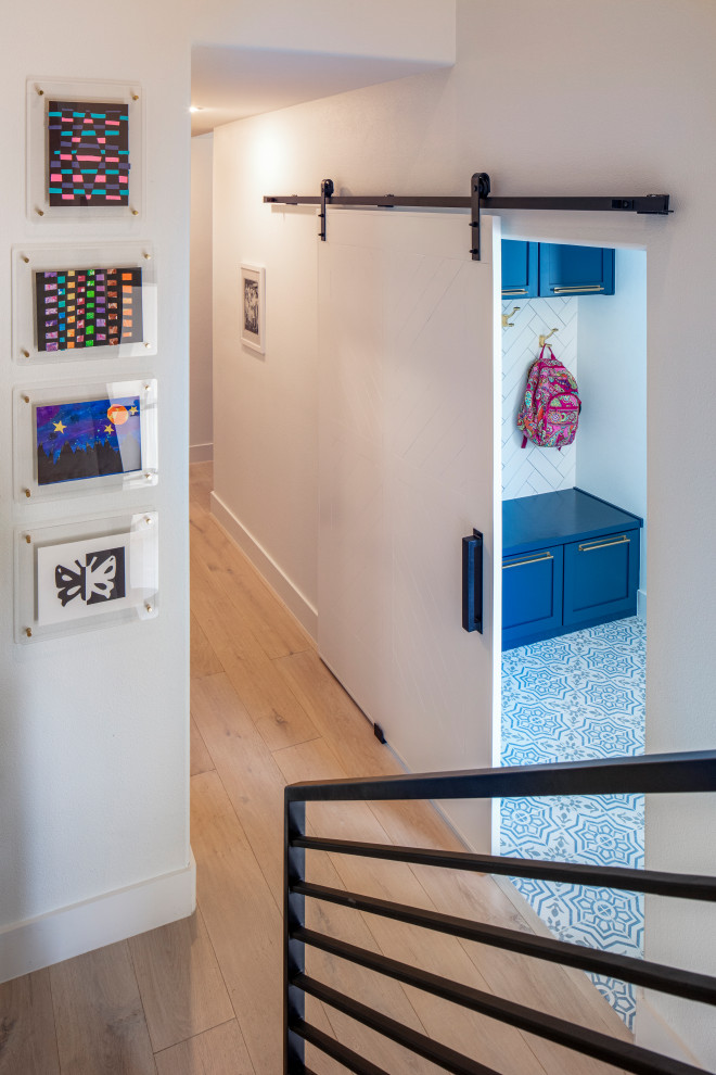 Mid-sized transitional light wood floor and beige floor hallway photo in Austin with white walls