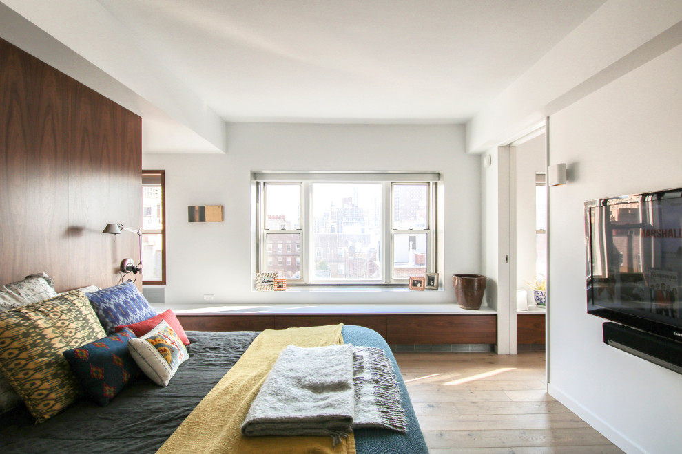 Small contemporary bedroom in New York with white walls and light hardwood floors.