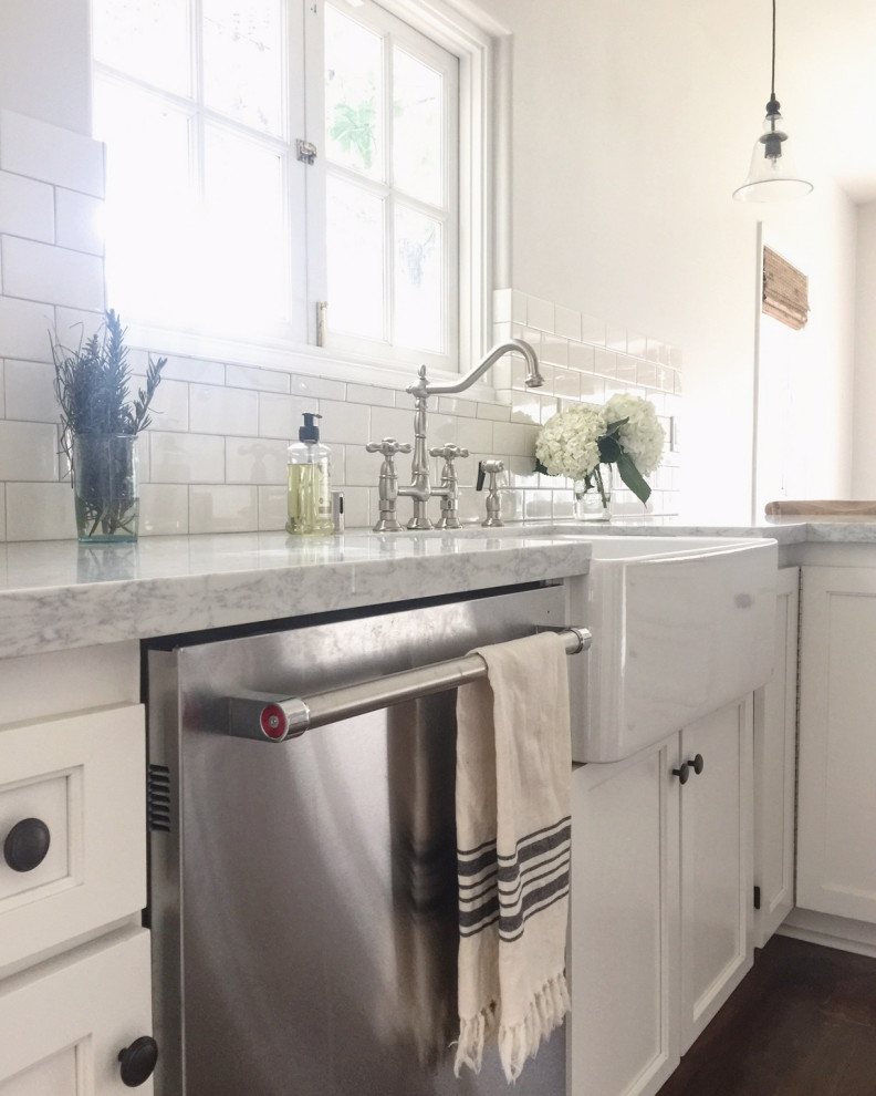 Inspiration for a traditional l-shaped kitchen in Los Angeles with white cabinets, recessed-panel cabinets, a farmhouse sink and dark hardwood floors.