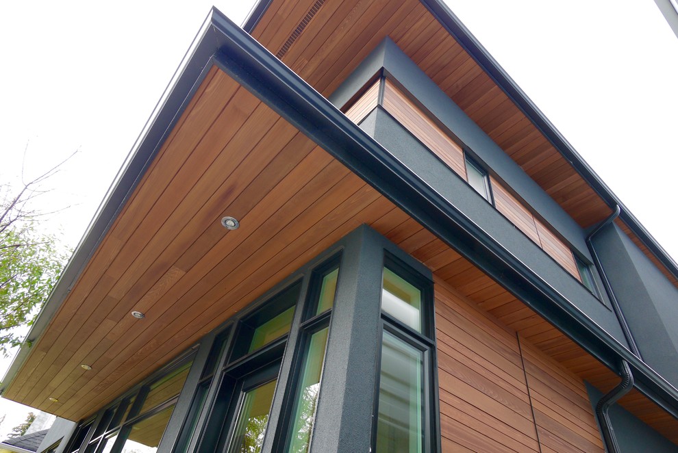 Mid-sized contemporary two-storey grey exterior in Calgary with wood siding.