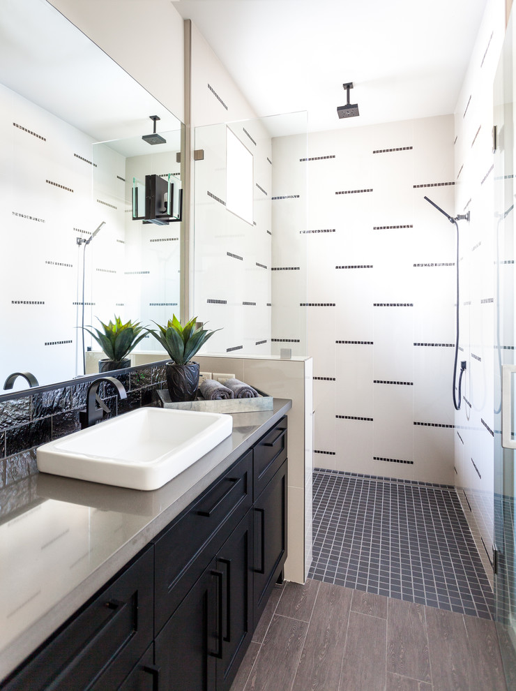 Photo of a transitional bathroom in Sacramento with a drop-in sink, recessed-panel cabinets, black cabinets, engineered quartz benchtops, porcelain tile, white walls, porcelain floors, black and white tile and grey benchtops.