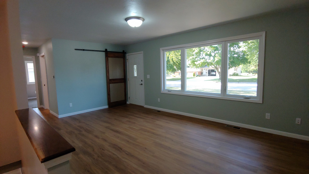 Foto di un piccolo soggiorno tradizionale aperto con pareti grigie, pavimento in vinile, TV a parete e pavimento marrone