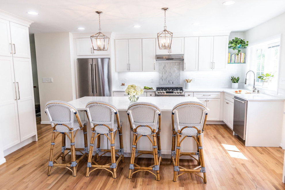 Eat-in kitchen - mid-sized transitional l-shaped light wood floor and brown floor eat-in kitchen idea in Baltimore with an undermount sink, shaker cabinets, white cabinets, quartz countertops, white backsplash, marble backsplash, stainless steel appliances, an island and white countertops
