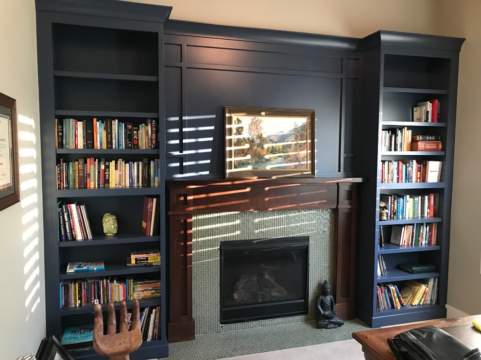 Inspiration for a mid-sized transitional home office in Salt Lake City with a library, beige walls, carpet, a standard fireplace, a tile fireplace surround, a freestanding desk and beige floor.