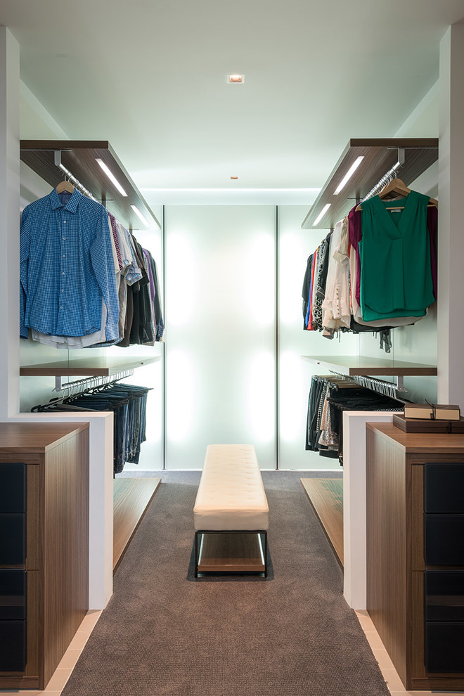 Inspiration for a contemporary gender-neutral walk-in wardrobe in Houston with open cabinets, dark wood cabinets, carpet and grey floor.