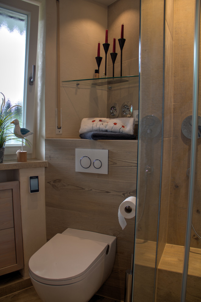Bild på ett litet vintage vit vitt badrum med dusch, med släta luckor, beige skåp, en kantlös dusch, en toalettstol med separat cisternkåpa, beige kakel, beige väggar, ett integrerad handfat, bänkskiva i glas, brunt golv och dusch med gångjärnsdörr