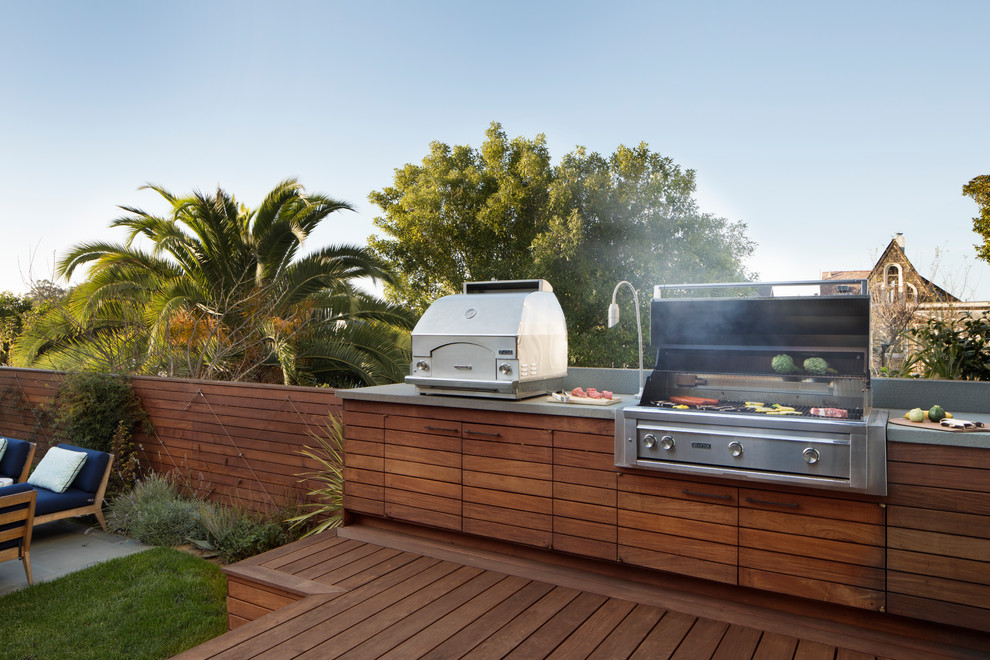 This is an example of a mid-sized contemporary backyard deck in San Francisco with an outdoor kitchen and no cover.