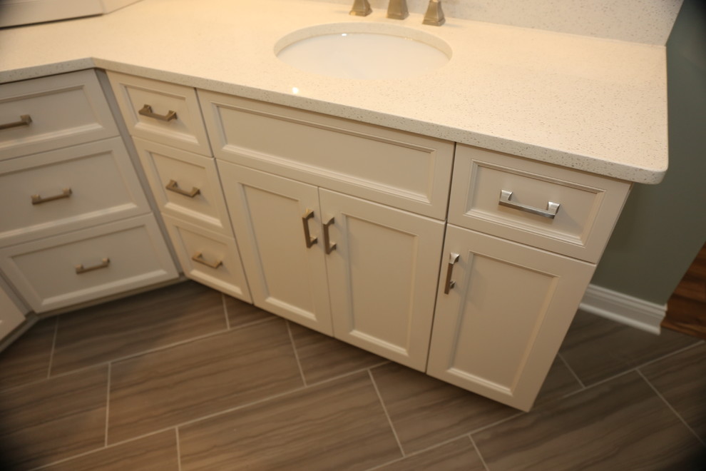 Photo of a large arts and crafts bathroom in Chicago with recessed-panel cabinets, white cabinets, porcelain floors, an undermount sink and grey floor.