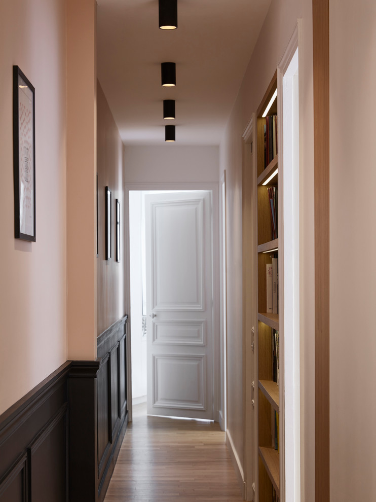 На фото: коридор среднего размера в современном стиле с розовыми стенами и коричневым полом