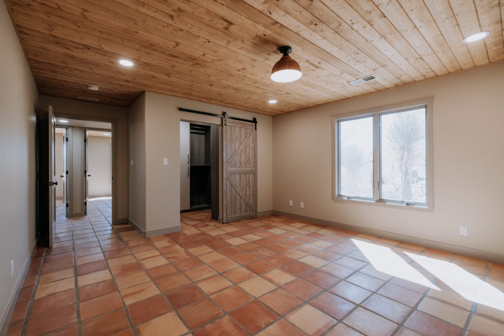 Bedroom - large southwestern master terra-cotta tile and orange floor bedroom idea in Albuquerque with beige walls