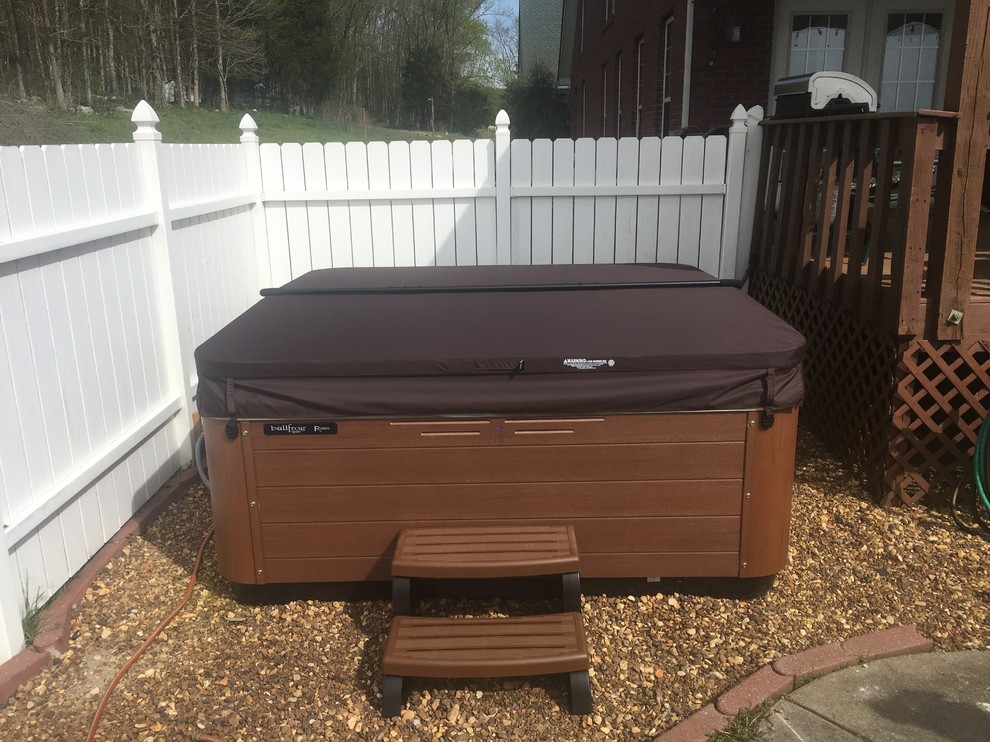 Inspiration for a mid-sized transitional backyard gravel and rectangular hot tub remodel