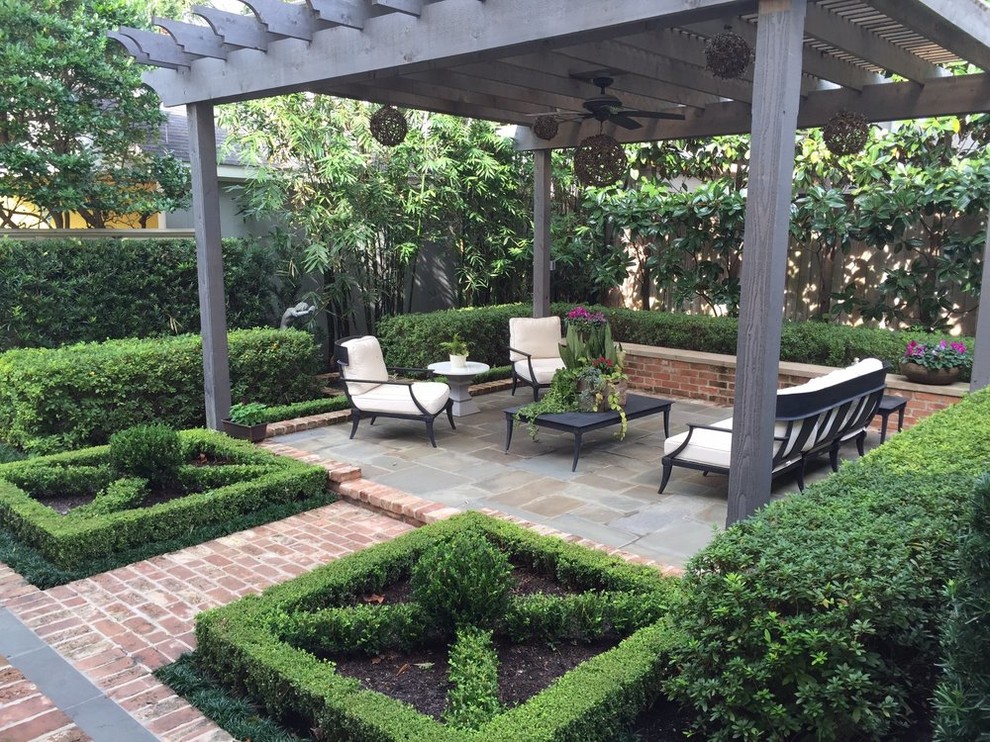 Inspiration for a mid-sized transitional backyard patio in Houston with natural stone pavers and a pergola.