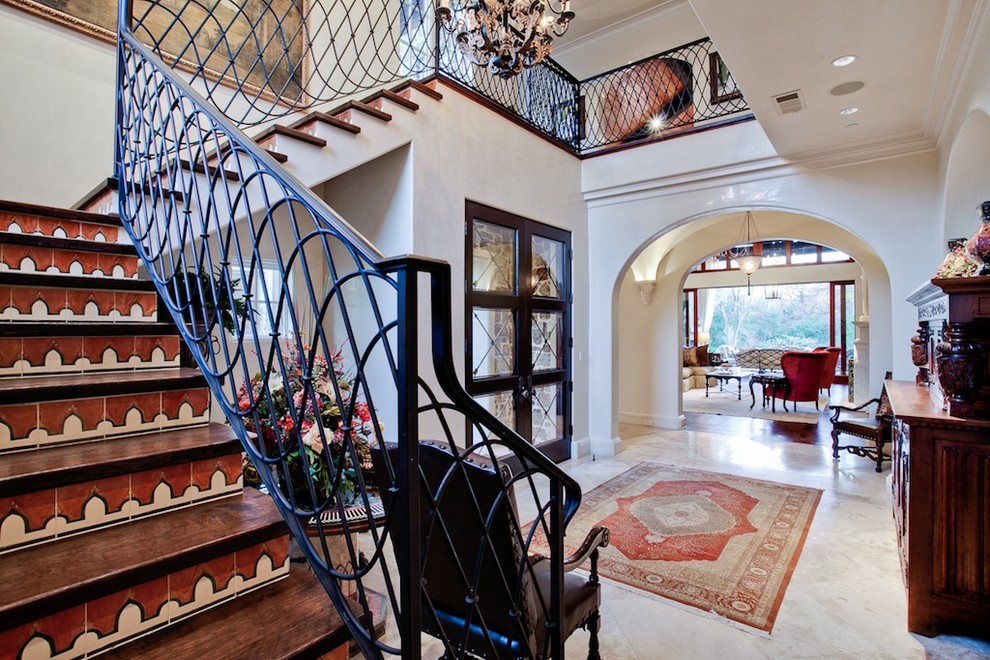Mediterranean wood l-shaped staircase in Dallas with tile risers.