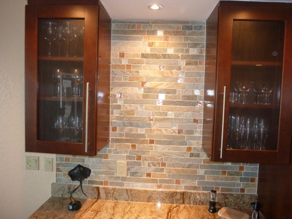 Inspiration for a mid-sized transitional single-wall wet bar in Tampa with no sink, glass-front cabinets, medium wood cabinets, granite benchtops, multi-coloured splashback and stone tile splashback.