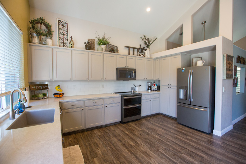 Design ideas for a traditional kitchen in Sacramento with an undermount sink, shaker cabinets, beige cabinets, quartz benchtops, white splashback, stainless steel appliances, porcelain floors and brown floor.