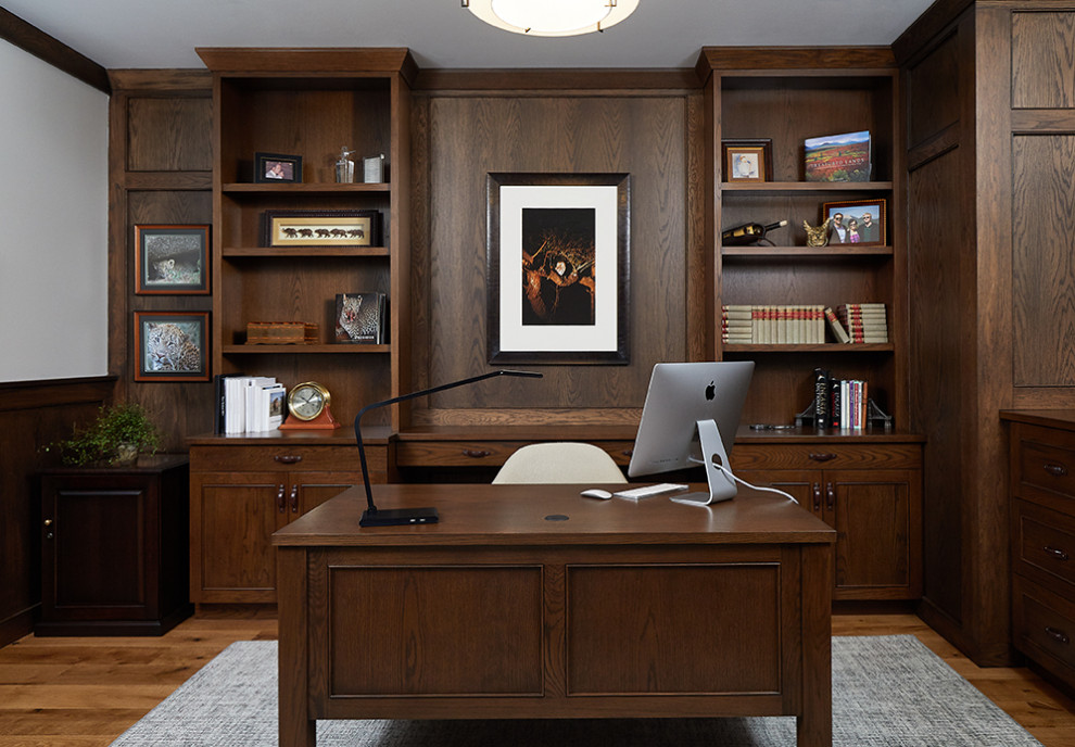 Example of a large transitional freestanding desk medium tone wood floor, brown floor and wood wall study room design in Grand Rapids with white walls
