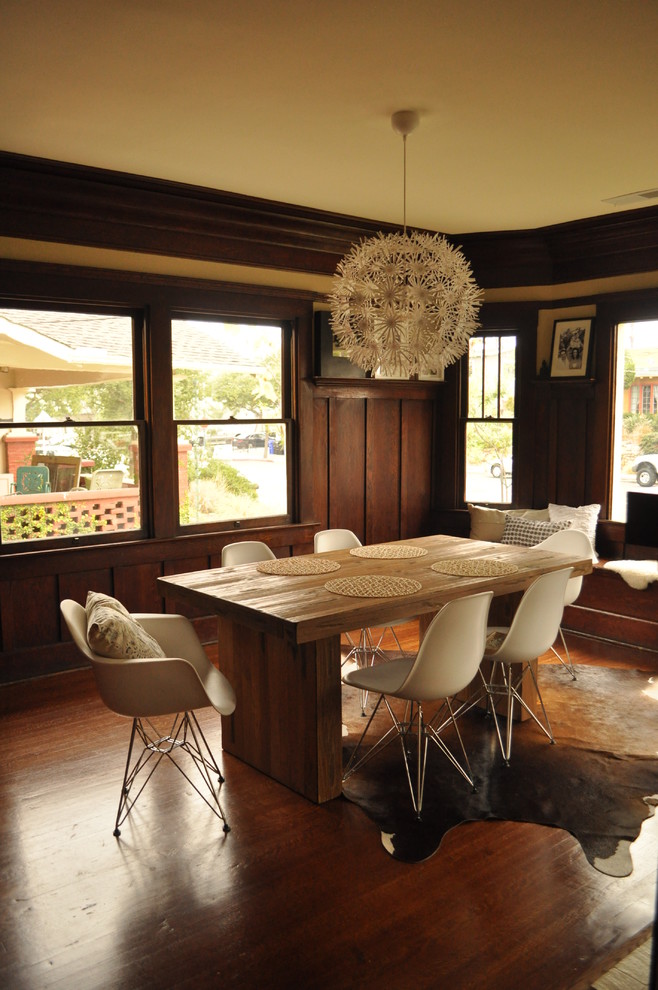 This is an example of a midcentury dining room in San Diego with dark hardwood floors.