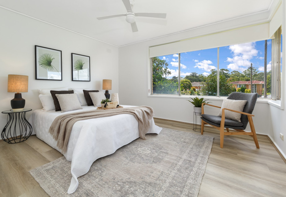 Design ideas for a mid-sized transitional master bedroom in Sydney with white walls and laminate floors.