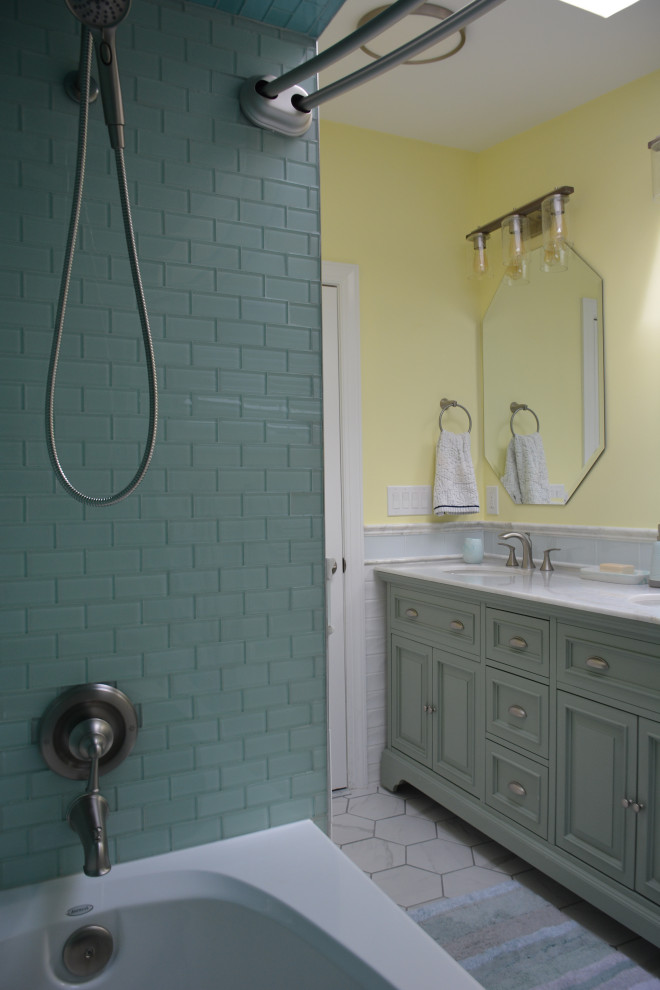 Design ideas for a mid-sized beach style kids bathroom in New York with raised-panel cabinets, green cabinets, an alcove tub, a shower/bathtub combo, a one-piece toilet, white tile, ceramic tile, yellow walls, ceramic floors, an undermount sink, marble benchtops, white floor, a shower curtain, white benchtops, a double vanity, a freestanding vanity and vaulted.